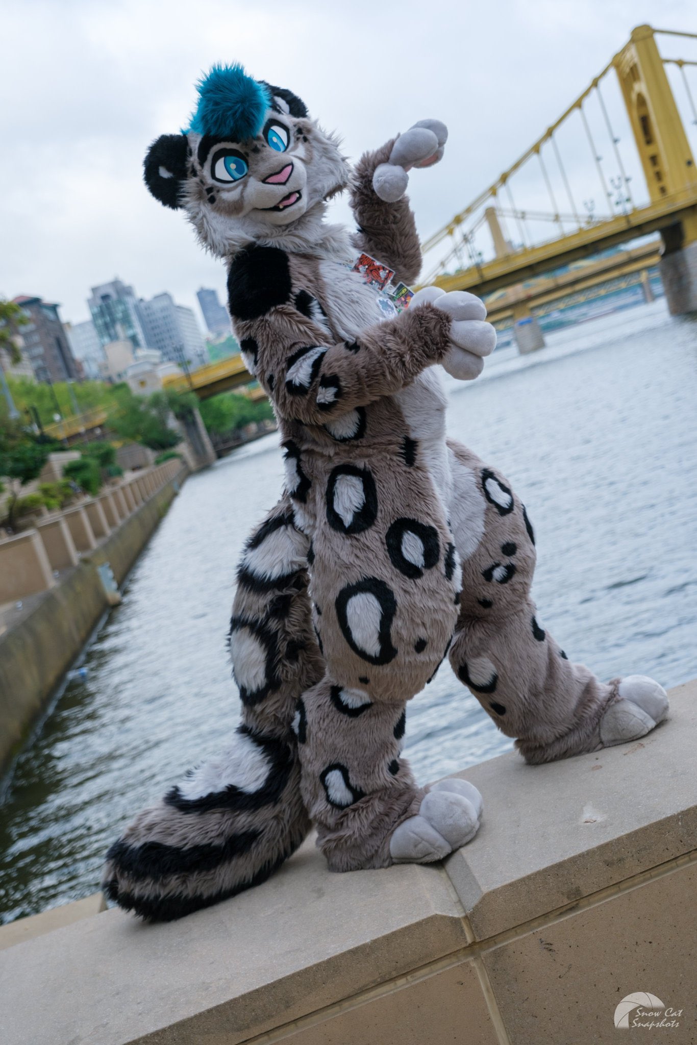 Costumed character posing beside a river and bridge